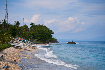 Traditional local colored fisherman's catamaran boats are lined up on the ocean shore on an island in Indonesiaの写真素材
