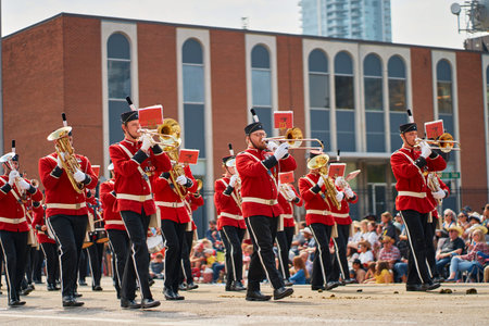Marching bands perform in the Stampede Parade held in Calgary. Musicians in uniforms play instruments while crowds gather to watch the event. The activity is lively and full of energy. 07.07.2023 - Calgary, Canada