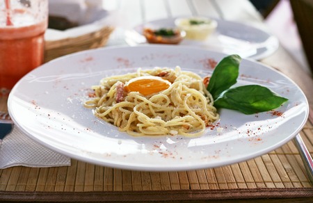 Delicious Italian pasta carbonara on a white plateの写真素材