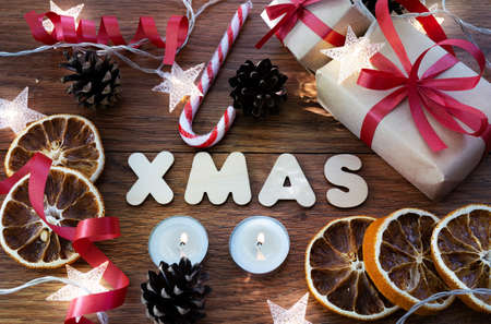 Christmas composition on a dark wooden background with gifts, toys and a garland, top view....