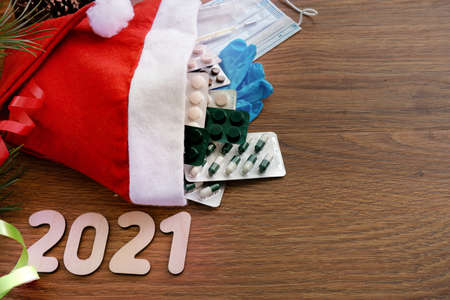 Santa Claus hat with medical supplies. New year's composition. The view from the top. Numbers 2021....