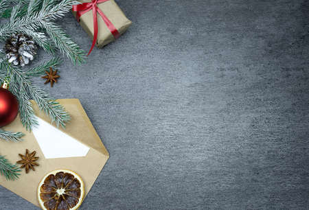 Christmas composition on a gray background with a gift, a twig and other ornaments. Top view. Christmas. There is a place for the text. High quality photoの写真素材