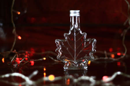 A clear glass bottle shaped like a leaf.