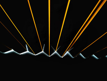 A black background with yellow and orange light lines projected as stripes, and a bar of white light.の写真素材