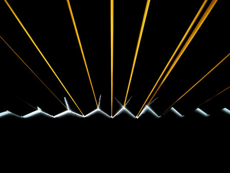 A black background with yellow and orange light lines projected as stripes, and a bar of white light.の写真素材