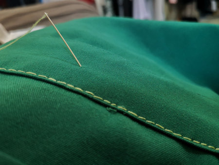Needle, sewing, fabric repair, green fabric with light green thread, sewing in a straight line.