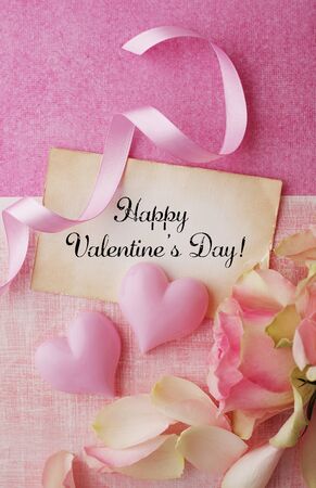 greeting card, ribbon and rose petals - pink hearts on pink paper background. Valentine's Day, birtday, mother's day or other celebrationの写真素材