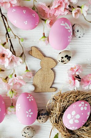 colorful easter eggs and spring flowers on white wooden backgroundの写真素材