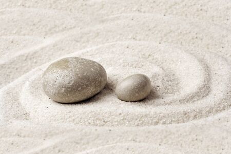 zen meditation stone. Round rock in sand texture background. Concept for yoga or spa welness...