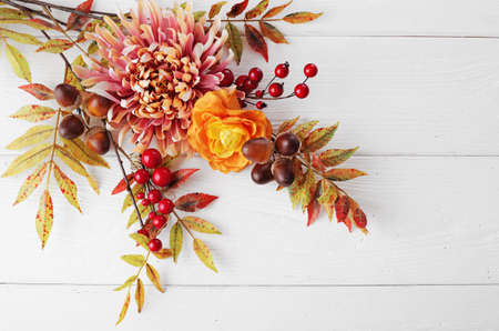 colorful leaves, pumpkin, nuts, apples and mushrooms on wooden backgroundの写真素材