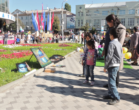 woman and her childrens have a good look at paintings on the street art exhibition and saleのeditorial素材