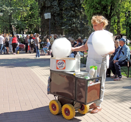 Saleswoman of cotton candy with hand cart in the city public gardenのeditorial素材