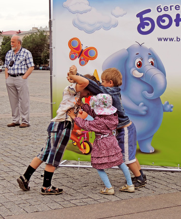 Jostleing of elementary age children with each other among city dwellers in the city square on the Music Festival of Children's Brass Bandsのeditorial素材