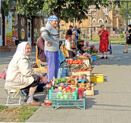 Senior women sell vegetables and fruits from their own gardens on the sidewalk of city streetのeditorial素材