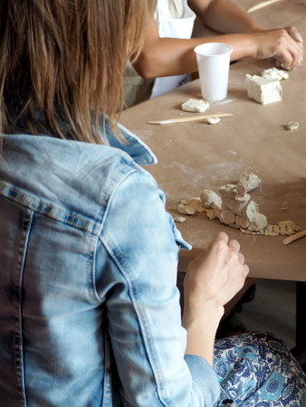 Woman sculpts from clay locomotive and railroad in the hobby groupの写真素材
