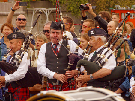 Bagpipers of Celtic pipes and drums band surrounded by townspeople in the Park of arts "Muzeon" on the Crimean embankment, Moscow. Festival of military orchestras "Spasskaya Tower".のeditorial素材