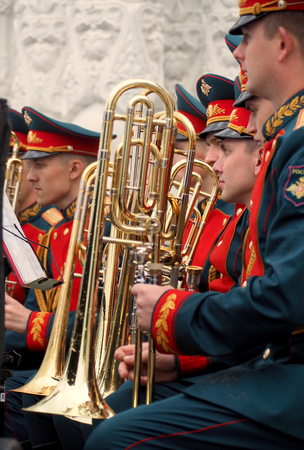 Military brass band trombonists are holding their trombones covered with raindrops. Festival of military orchestras "Spasskaya Tower". Central Avenue in the Park of VDNH, Moscow.のeditorial素材