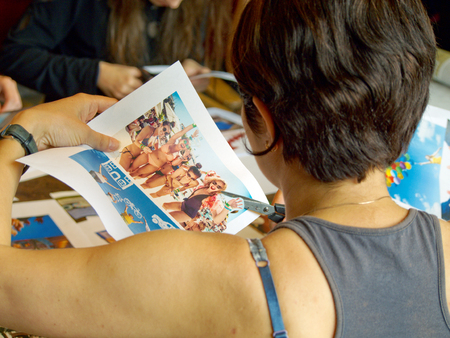 Woman with scissors cuts out a picture from a magazine in the training realizing the dreamのeditorial素材