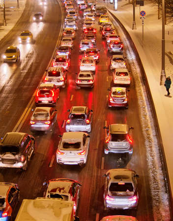 Cars standing in traffic on the street in the city in the evening in winterのeditorial素材