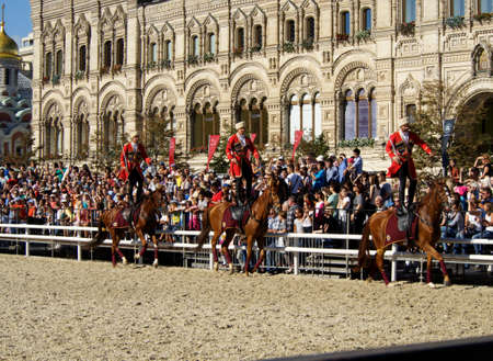 Moscow, Russia - Aug 28, 2016: A group of riders in Circassians and papakhas performs a trick riding standing on Bay horses near the State Department Store. Festival Spasskaya Towerのeditorial素材