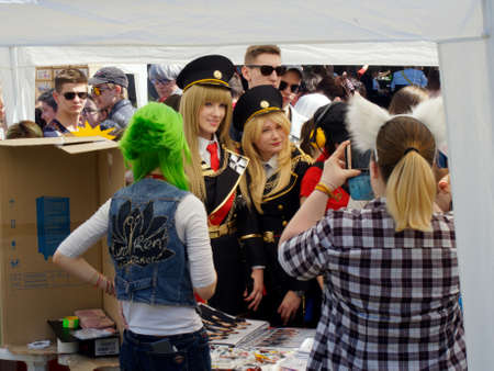 Voronezh, Russia - May 1, 2018: Blonde adult girls in military uniforms among other park visitors at a kiosk with Souvenirs. All-Russian festival of Japanese animationのeditorial素材