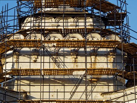 Reconstructed building with decorative elements in scaffoldingの写真素材