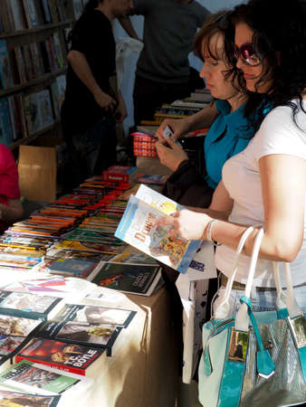 Voronezh, Russia - June 12, 2016: A female customer holds an open book at the counter at the Book fairのeditorial素材
