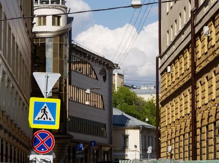 City street with one-story and multi-story residential buildings of old construction and a modern office buildingの写真素材