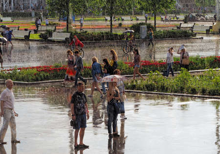 Moscow, Russia - May 28, 2016: People walking in the Park during an unexpected spring rainの写真素材