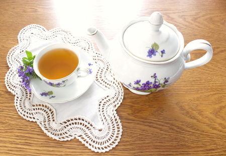 Old china tea service with bouquet of violetsの写真素材