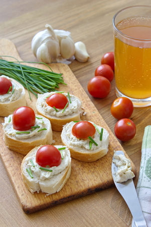pieces of bread spread with broccoli tomatoes and garlic chivesの写真素材