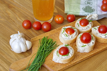 bread pieces with vegetable spread chives and tomatoesの写真素材