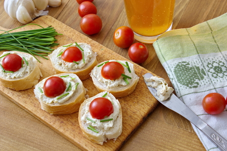 bread pieces with vegetable spread chives and tomatoesの写真素材