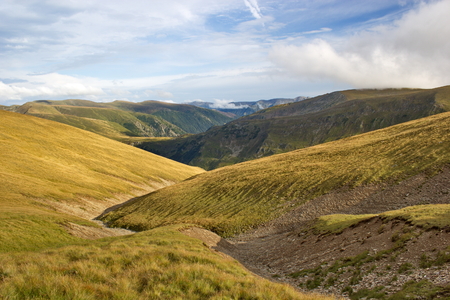 long zigzag path Between hills, Fagaras mountains, Romaniaの写真素材