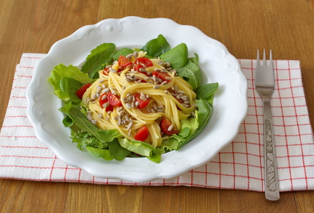 Consists healthy lunch of corn spaghetti, salad, seeds and tomatoesの写真素材