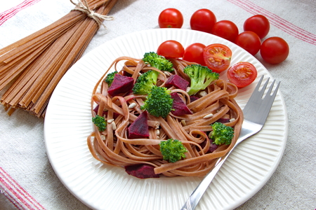 whole grain spaghetti with fresh broccoli, beetroot and tomatoesの写真素材