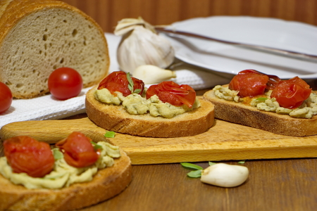 toasts with baked tomatoes, homemade broccoli cream and garlicの写真素材