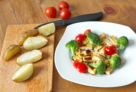 pieces of tofu with fresh vegetable and baked potatoesの写真素材