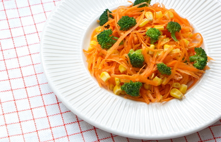 healthy fresh carrot salad with pieces of broccoli and cornsの写真素材