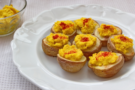 hummus with pepper served on baked potatoesの写真素材