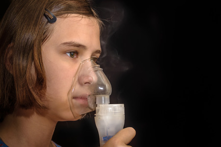 sick girl inhalation therapy by the mask of inhalerの写真素材