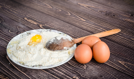 flour and eggs for pastries on a wooden background, retro styleの写真素材