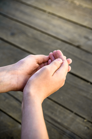 children's hands on a wooden background. Close-upの写真素材
