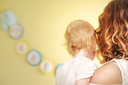 mother with a baby in her arms with her back to the camera.の写真素材