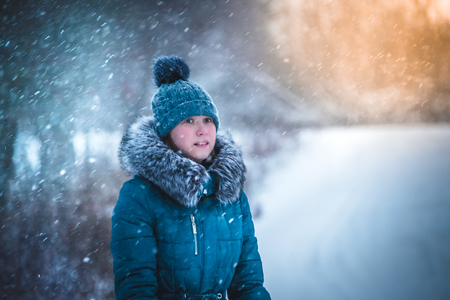 girl walking in winter blizzard, colorful winter hatの写真素材