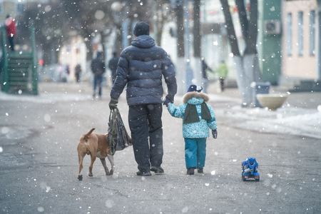 Father and little kid on the street in winterの写真素材