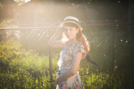Girl in hat and long hair at sunset - sunlight and back view conceptの写真素材