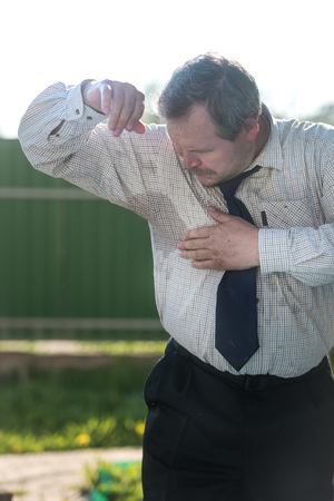 Business man with sweating under armpit on natureの写真素材