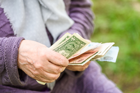 The old woman considers banknotes - hands and money close upの写真素材
