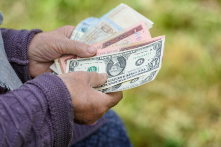 The old woman considers banknotes - hands and money close upの写真素材